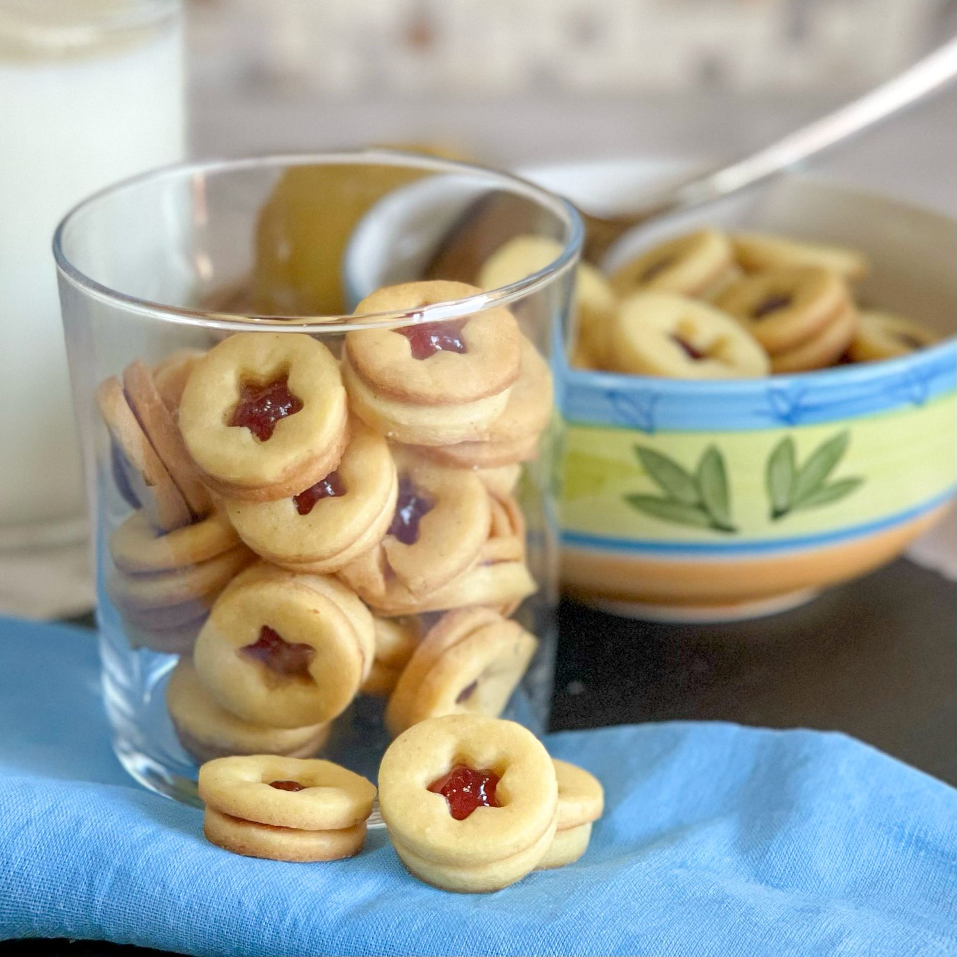 Un bicchiere pieno di biscotti accanto a una ciotola di biscotti