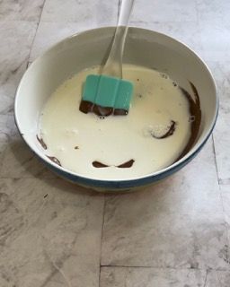 Una ciotola di latte e cioccolato con una spatola dentro