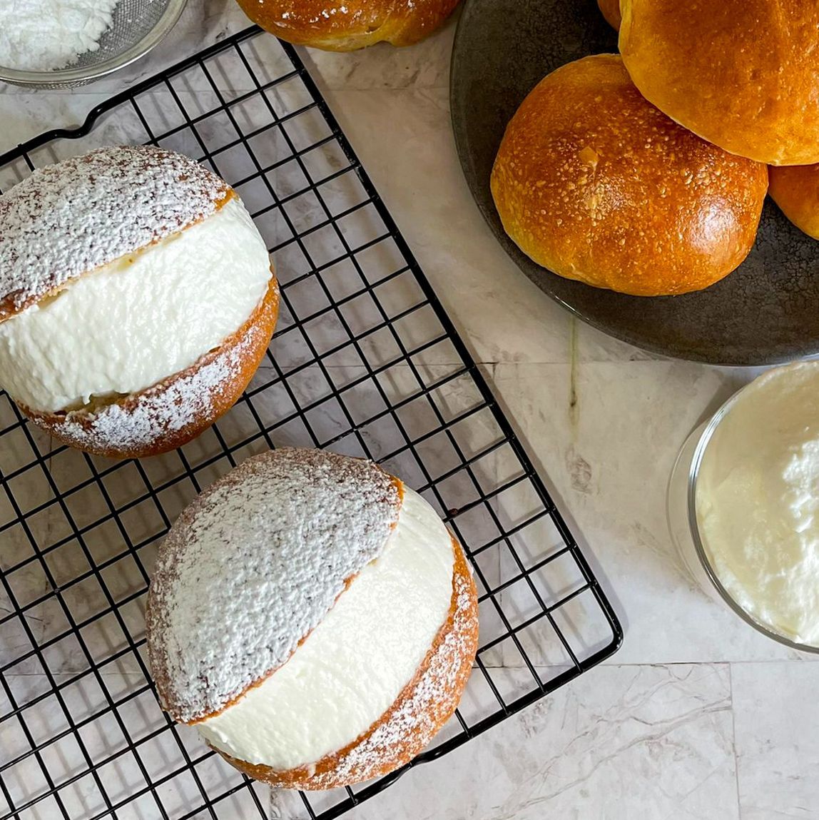 Un mucchio di pasticcini sono appoggiati su una griglia di raffreddamento