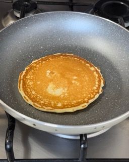 Un pancake sta cuocendo in una padella sul fornello