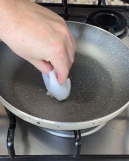 Una persona sta pulendo una padella con una spugna