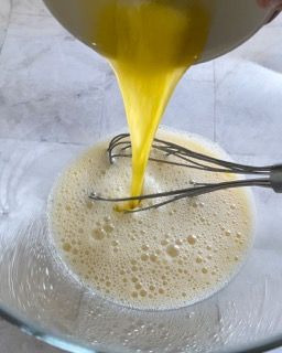 Le uova vengono versate in una ciotola di vetro con una frusta
