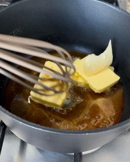 Una padella con burro e una frusta dentro