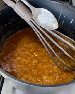 Una pentola di salsa con dentro cucchiai e fruste