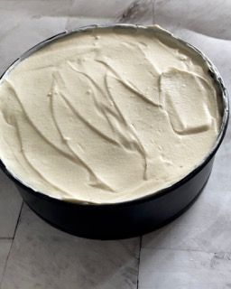 Una padella nera piena di glassa bianca su un tavolo