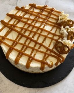 Una cheesecake con salsa al caramello e pretzel sopra