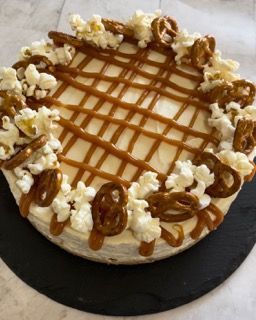 Una cheesecake con popcorn e pretzel sopra