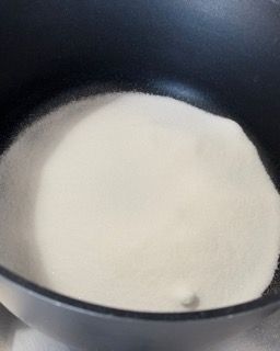 Su un tavolo c'è una padella piena di polvere bianca.