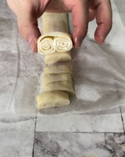 Una persona tiene in mano un pezzo di pasta.