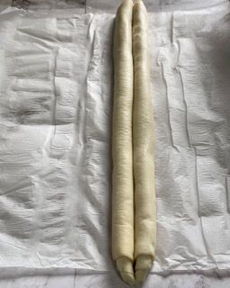 Due rotoli di pasta sono appoggiati su un pezzo di carta oleata.