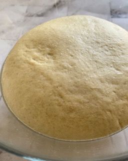 Primo piano di un impasto in una ciotola di vetro su un tavolo.