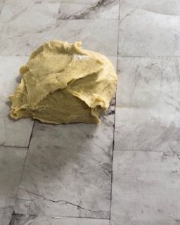 Un mucchio di pasta è appoggiato su un pavimento piastrellato.