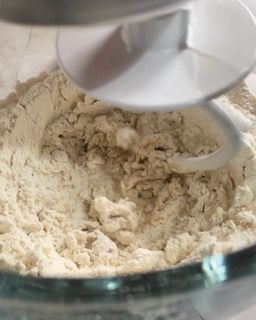 Un mixer mescola la farina in una ciotola di vetro.