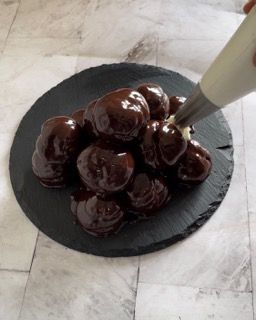Un mucchio di palline ricoperte di cioccolato su un piatto nero