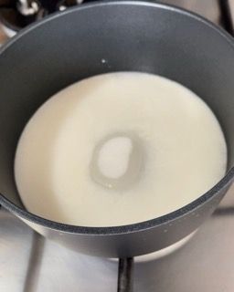 Una pentola piena di liquido bianco è posta sul fornello.