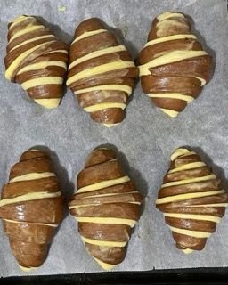 Un mucchio di croissant appoggiati su una teglia da forno