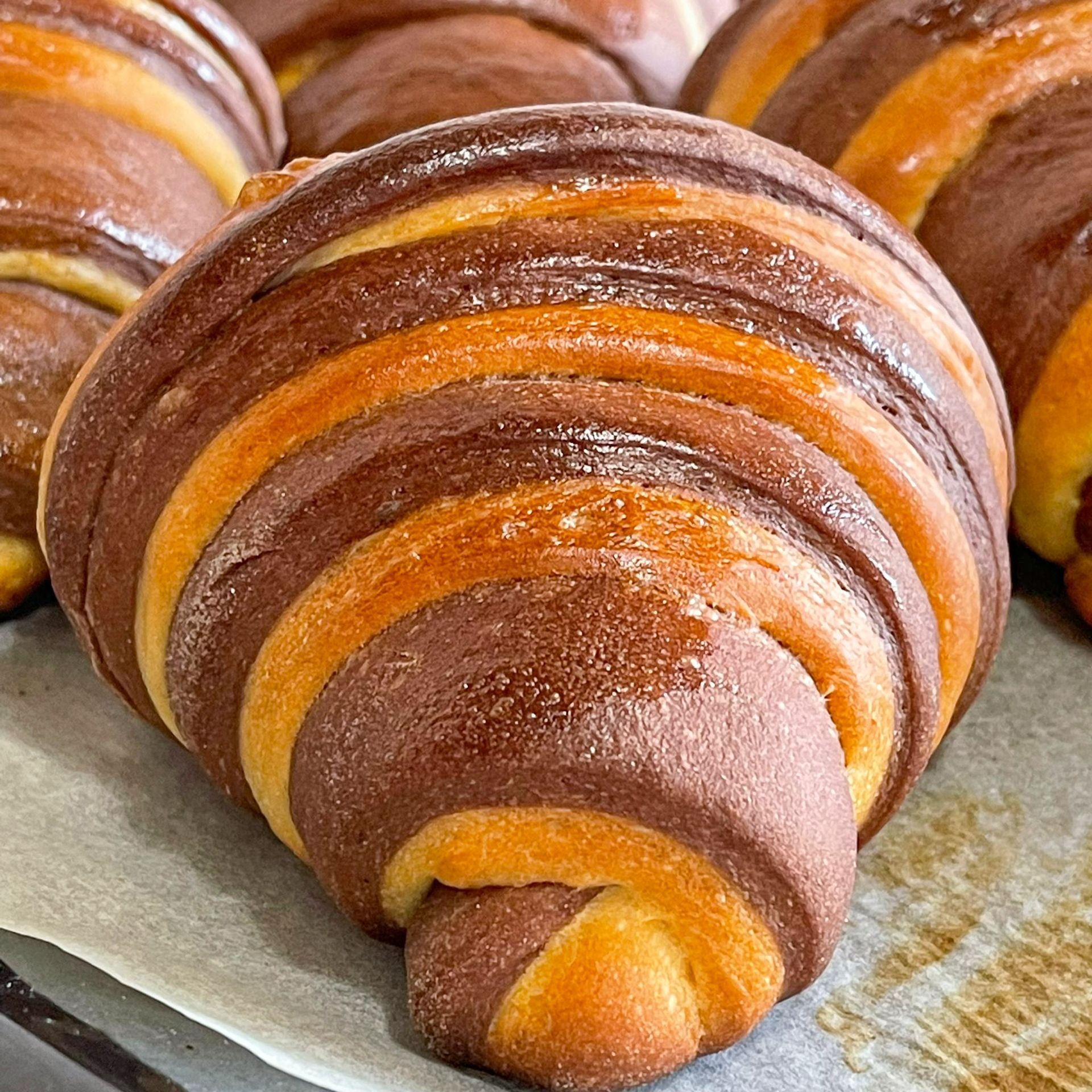 Primo piano di un croissant al cioccolato e vaniglia su un tavolo.