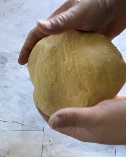 Una persona tiene in mano una palla di pasta.