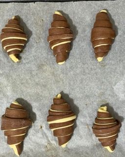 Un vassoio di croissant al cioccolato con strisce gialle sopra