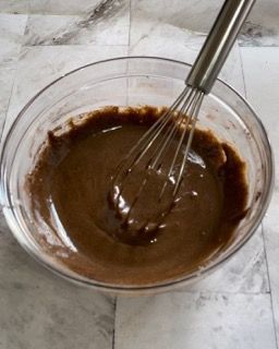 Una ciotola di salsa al cioccolato con una frusta dentro