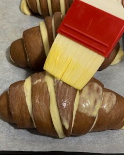 Un primo piano di un croissant con un pennello sopra