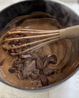 Una ciotola di salsa al cioccolato con una frusta dentro