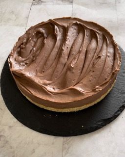 Una torta al cioccolato è appoggiata su un piatto nero