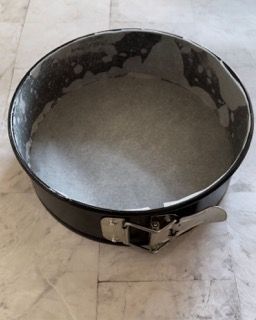 Una tortiera con un chiavistello è appoggiata su un pavimento piastrellato