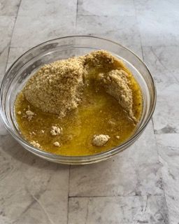 Una ciotola di vetro piena di un liquido giallo su un tavolo