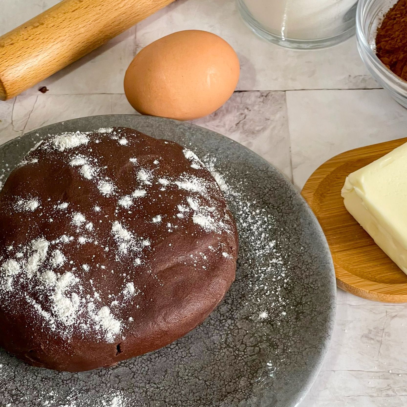 Un biscotto al cioccolato su un piatto accanto a uova e burro