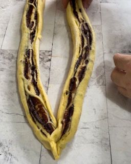 Inizio della treccia classica con i due filoni di babka al cioccolato.