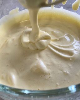 Un primo piano di una ciotola di salsa con un cucchiaio dentro.