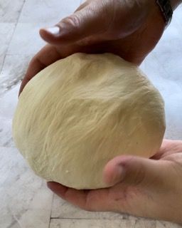 Una persona tiene in mano una palla di pasta