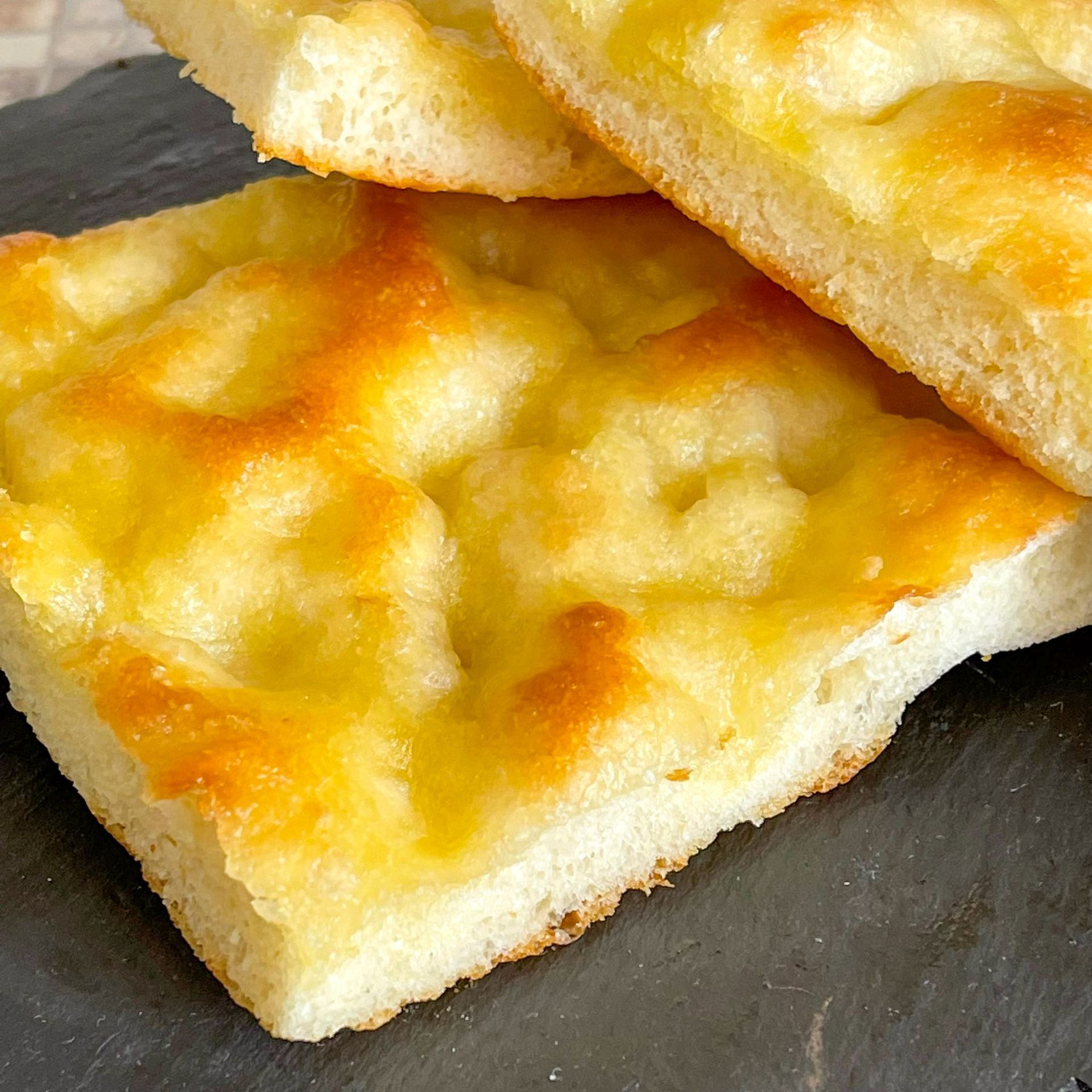 Due fette di pane sono disposte una sopra l'altra su un piatto nero.