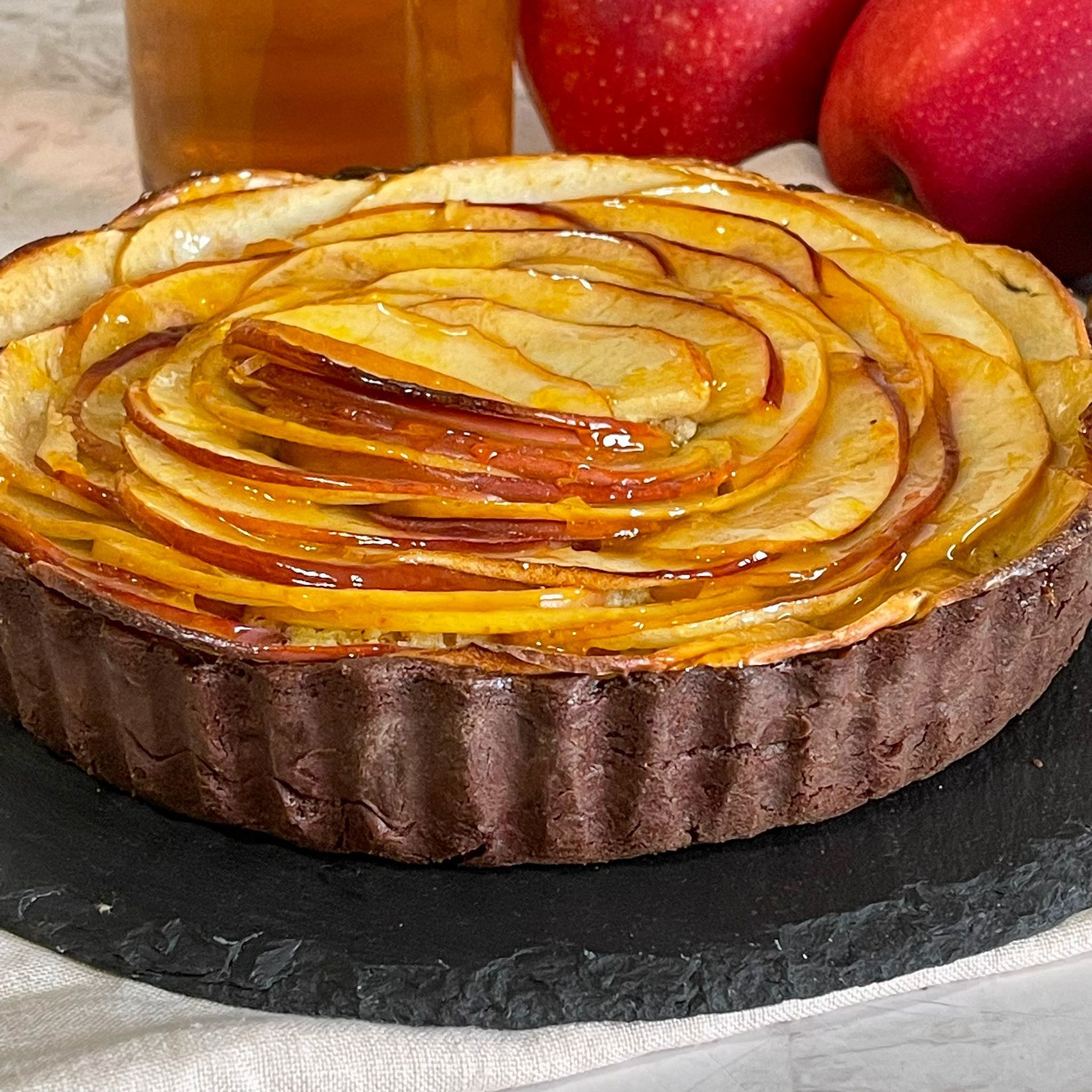 Una torta con sopra delle fette di mele, su un tavolo.