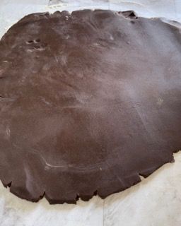 Un grosso pezzo di pasta al cioccolato è appoggiato su un tavolo.