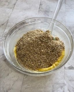 Una ciotola di cibo con un cucchiaio dentro su un tavolo.