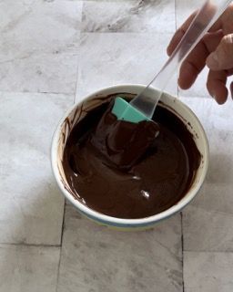 Una ciotola di salsa al cioccolato con una spatola dentro