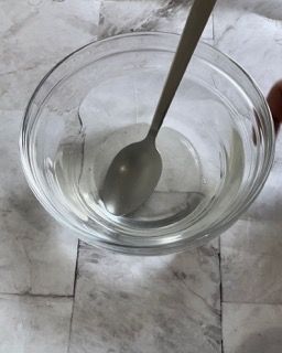 Una ciotola d'acqua con un cucchiaio dentro