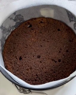 Una torta al cioccolato in una teglia ricoperta di carta oleata