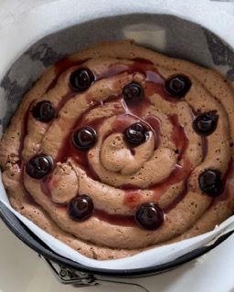 Una torta con glassa al cioccolato e ciliegie sopra