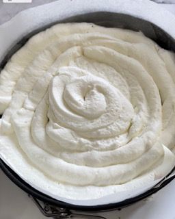 Una padella piena di panna montata è appoggiata su un tavolo.