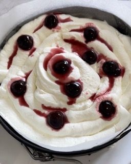 Una torta con panna montata e ciliegie sopra