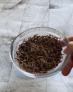 Una persona tiene in mano una ciotola di vetro piena di trucioli di legno