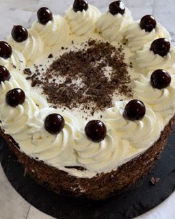 Una torta con panna montata e ciliegie sopra