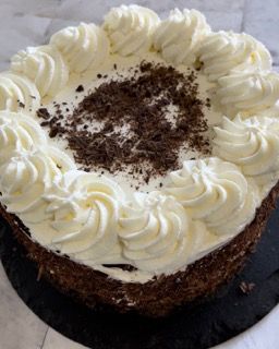 Una torta con panna montata e scaglie di cioccolato sopra