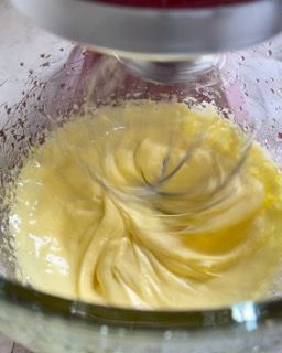 Un mixer sta mescolando un liquido giallo in una ciotola di vetro.