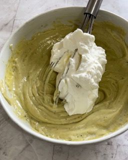 Una ciotola di salsa verde con panna montata e una frusta dentro