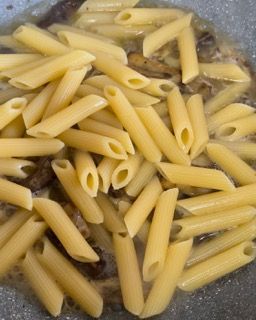 Un mucchio di pasta viene cucinato in una padella