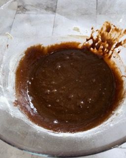 Una ciotola di vetro piena di liquido marrone su un tavolo